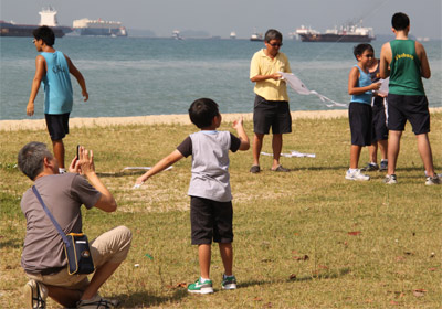 Dads kite-flying with their sons 