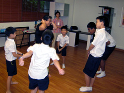 Ms Leong Chin Yee playing a game with her students at a Christian Fellowship session